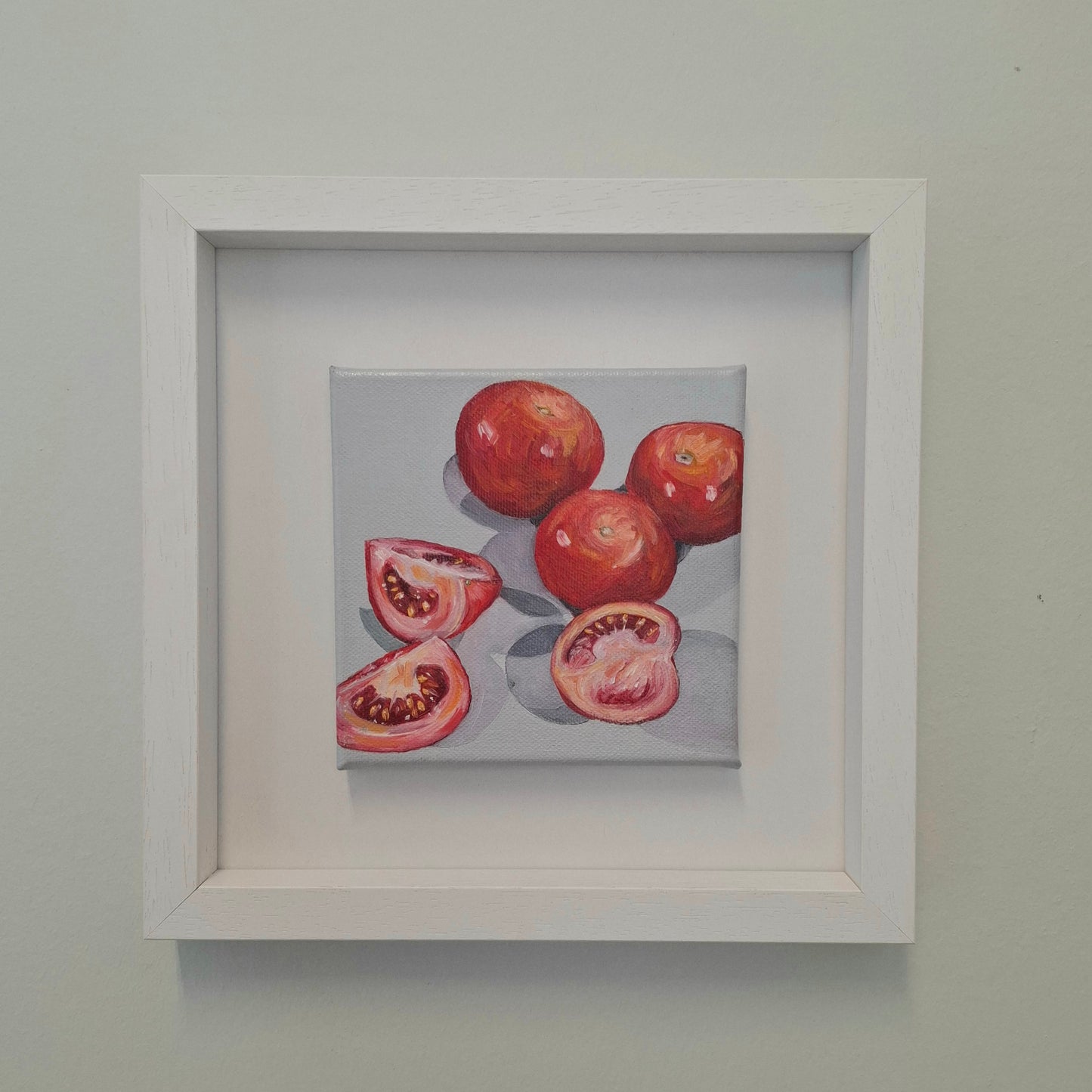 A still life oil painting of 3 tomatoes and 3 tomatoes segments. Also the shadows created between them. On grey background.