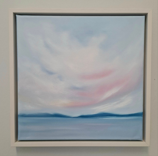 Oil painting. A skyscape of pink blue and white with blue mountains in the distance and water in the foreground. 